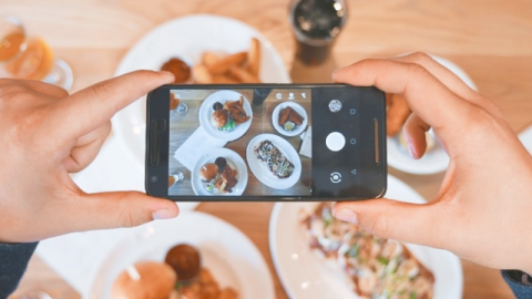 A smartphone taking a photo of plates of food